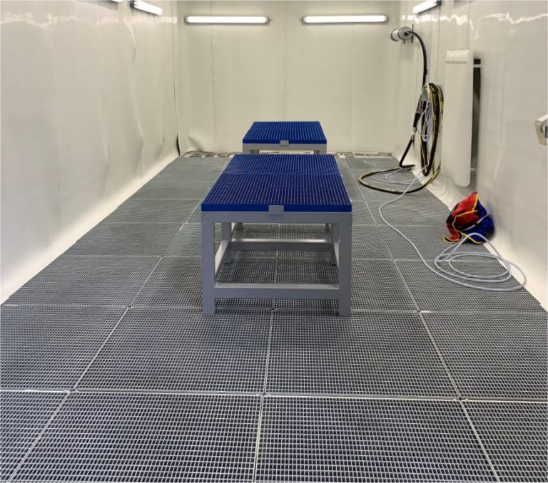 Die neue Strahlkabine im Einsatz mit Werkstücken auf einem Podest