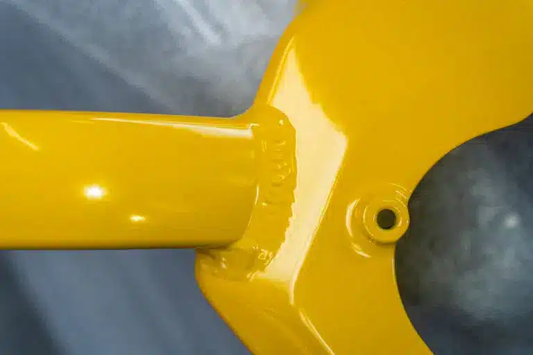 Nahaufnahme von einer Schweißnaht an einem gelben Werkstueck nach Pulverbeschichtung