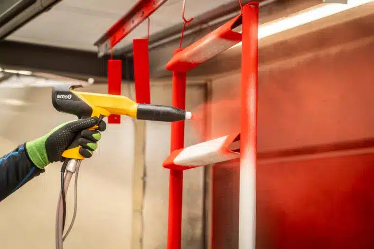 Nahaufnahme einer Spritzpistole bei der Pulverbeschichtung einer Industrieleiter