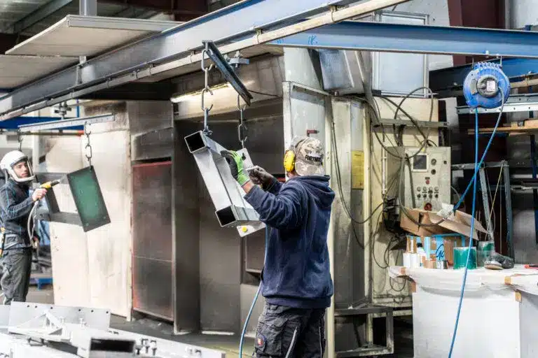 Zwei Mitarbeiter von KBN, wie sie gemeinsam die Werstücke für die Strahlkammer vorbereiten.