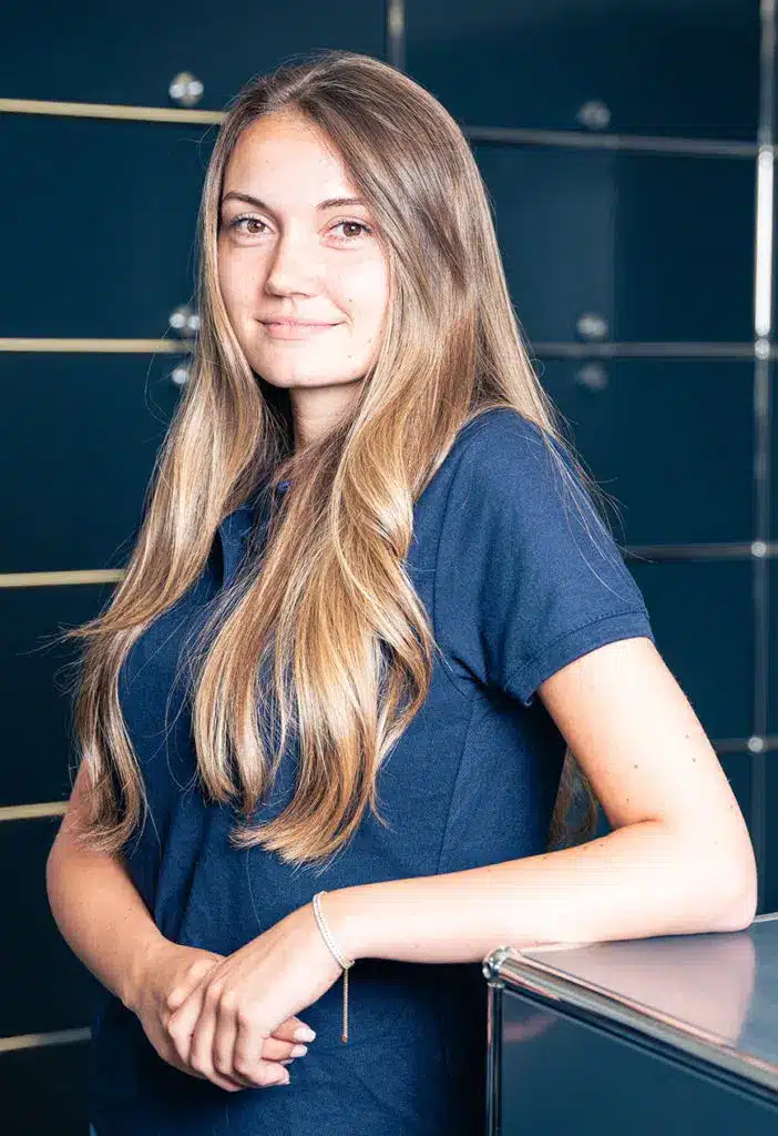 Junge, freundlich aussehende Mitarbeiterin, die Kundenanliegen sehr gerne entgegennimmt.